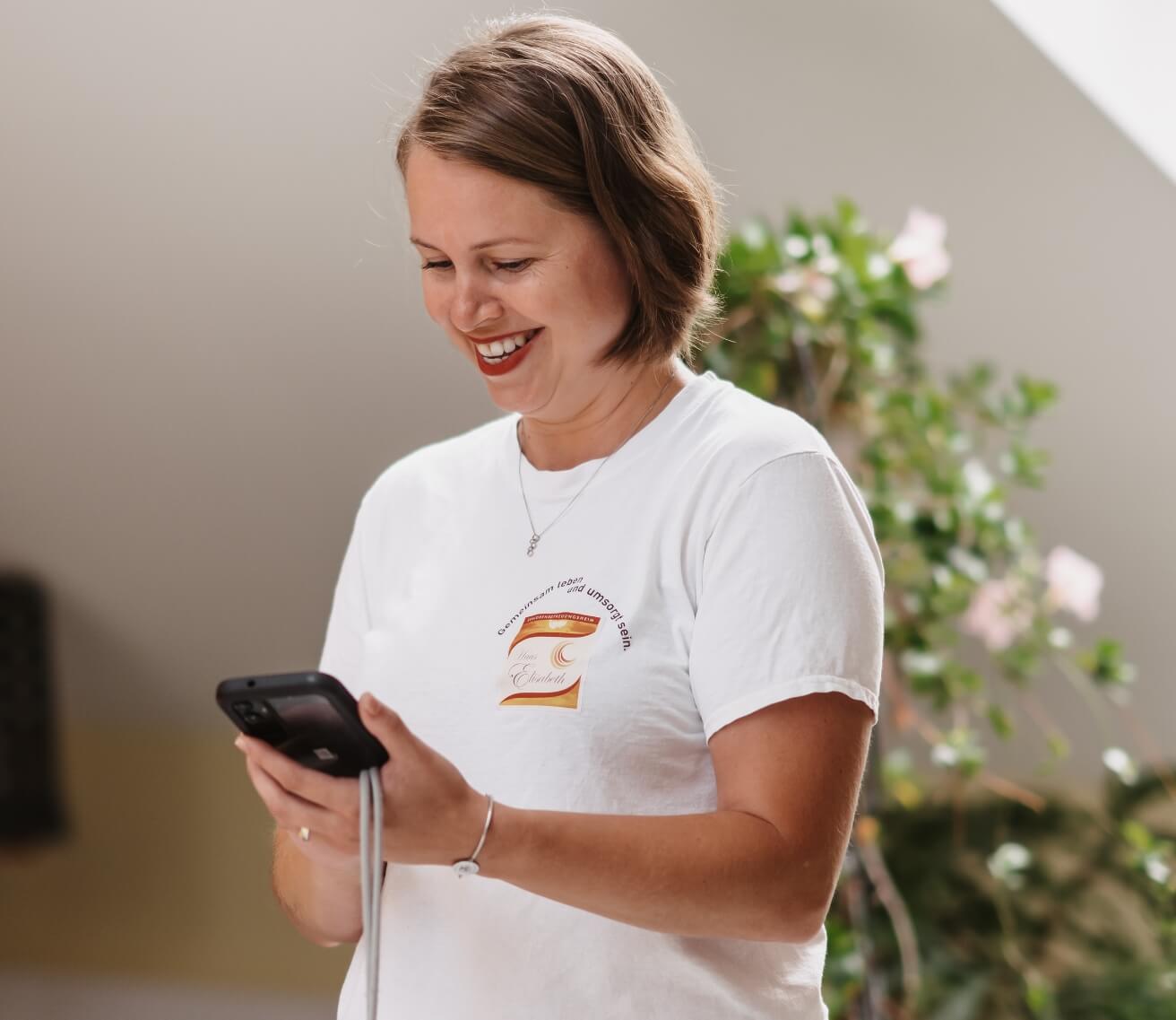 Pflegekraft fotografiert mit dem Smartphone, um ein Bild in der Pflegedokumentation zu erfassen