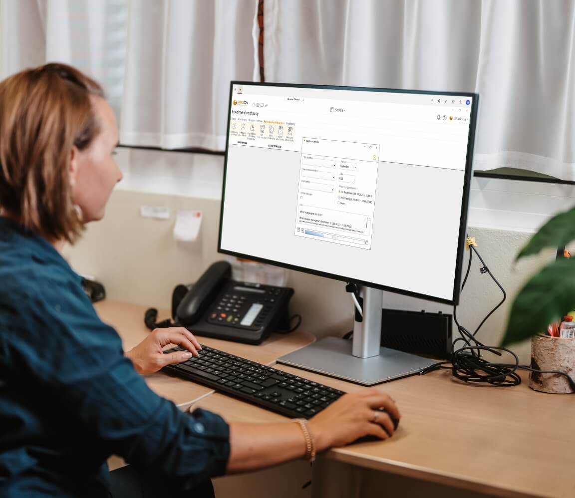 Mitarbeiterin erstellt Bewohnerabrechnung am Computer