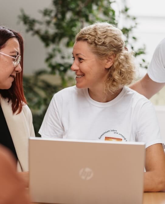 Mitarbeitende besprechen Auswertungen und Berichte am Laptop