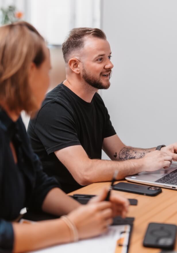 Mitarbeiter arbeitet im Büro mit Unterlagen und Laptop an der Finanzbuchhaltung